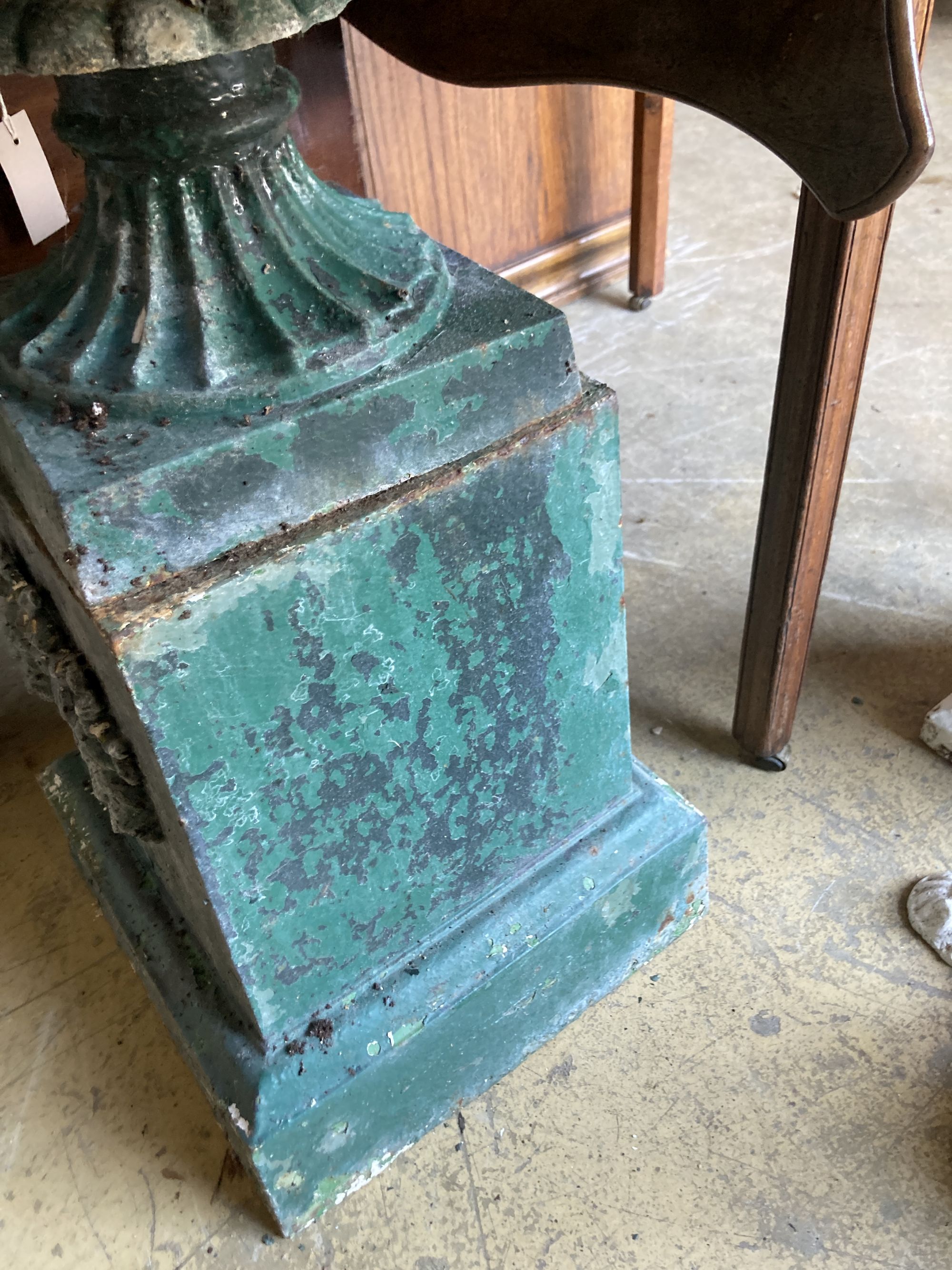 A Victorian green painted cast iron campana garden urn and pedestal, diameter 54cm, height 74cm